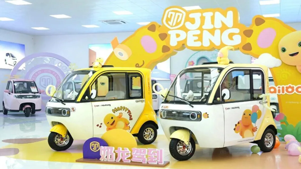 Two co-branded Jinpeng enclosed tricycles in a showroom display
